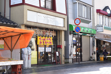 黄色の暖簾が目印の「セレクトフード のと×能登」。１階には食堂と厨房、食品加工設備などがあり、５LDKある２階が橋本さんの住まい。